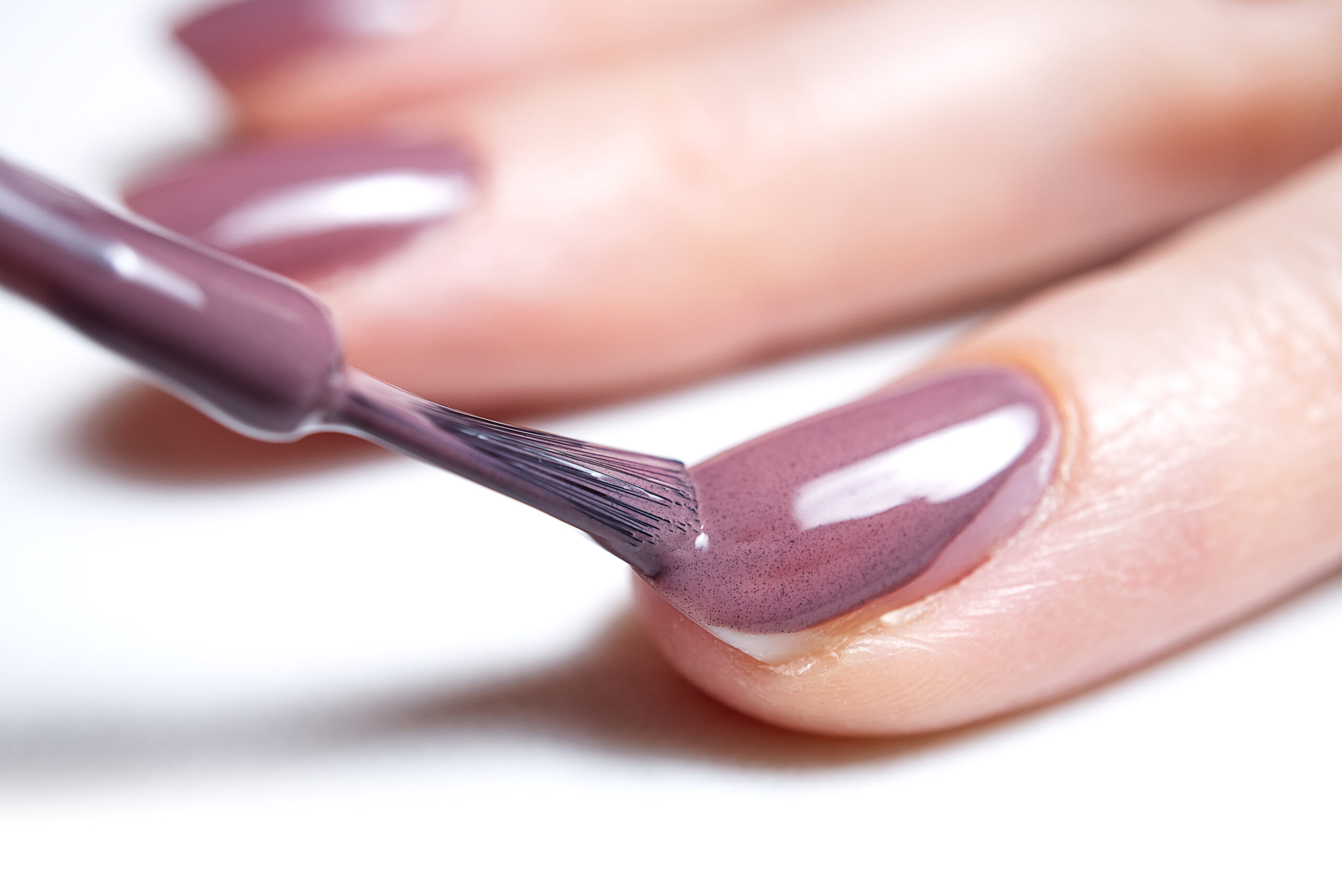 Woman applying nail polish. Beautiful nails. Woman applying polish on nails at home. Pastel nail polish on fingernail. Beauty treatment and hand care concept. manicure procedures yourself at home.