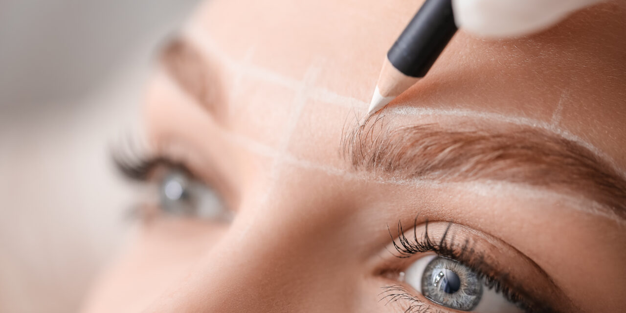 Young woman undergoing eyebrow correction procedure in beauty salon, closeup